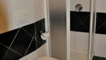 A bathroom with a toilet, bidet, and a shower enclosure.