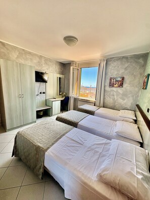 A hotel room with two beds, a desk, a chair, a TV, and a window with a view. - Albergo della Posta (Genoa)
