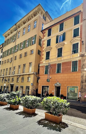 A multi-story hotel with a classic facade, green shutters, and a sign indicating it is a hotel. - Albergo della Posta (Genoa)