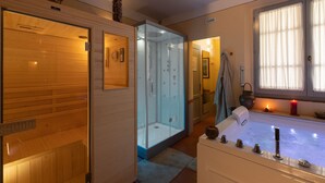 A sauna, a glass-enclosed shower, and a bathtub with a modern design. - Casa Bellavista (Cortona)
