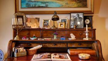 Un bureau en bois avec une lampe, des photos encadrées, une horloge et un livre.