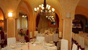 A banquet hall with round tables set for a formal event, featuring white tablecloths, glassware, and floral centerpieces. - Xabier (Javier)