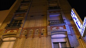 Fachada de hotel com várias sacadas, uma placa indicando que é um hotel e uma placa com o número 42.