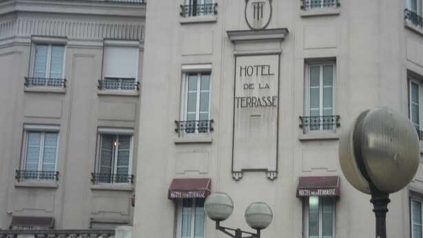 Un edificio con un letrero que dice "HOTEL DE LA TERRASSE".