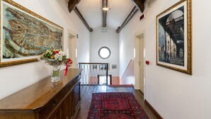 A hallway with a wooden ceiling, a round skylight, and two large framed paintings on the walls. - Villa Casanova (Venice)