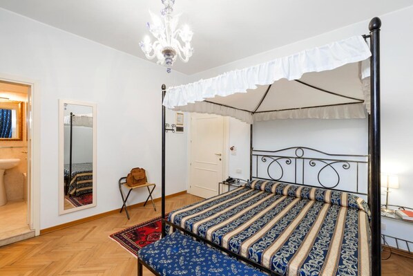 A four-poster bed with a canopy, a mirror, a small table, and a bench. - Villa Casanova (Venice)
