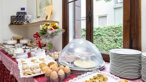 A breakfast buffet with pastries, eggs, and a variety of beverages. - Villa Casanova (Venice)