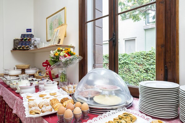 A breakfast buffet with pastries, eggs, and a variety of beverages. - Villa Casanova (Venice)