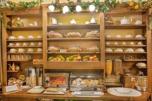 A buffet setup with various food items, including fruits and pastries, and a coffee station. - B&B L'Alloggio dei Vassalli (Naples)