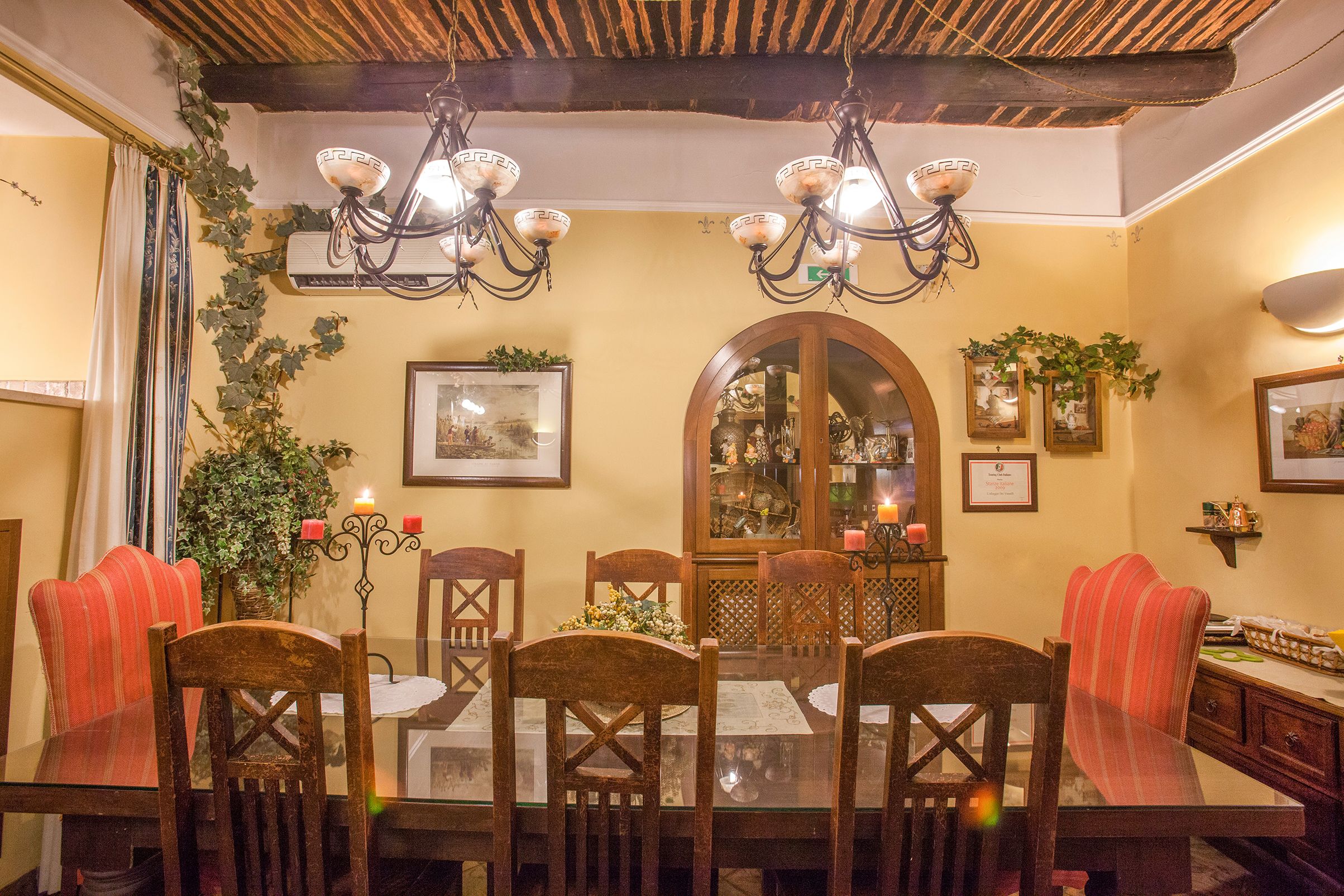 A dining area with a wooden table, chairs, and a chandelier.