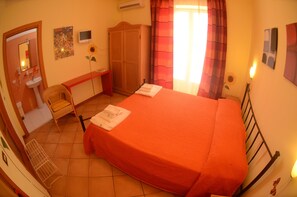 Una camera da letto con un letto, una scrivania, una sedia, un armadio e un bagno.