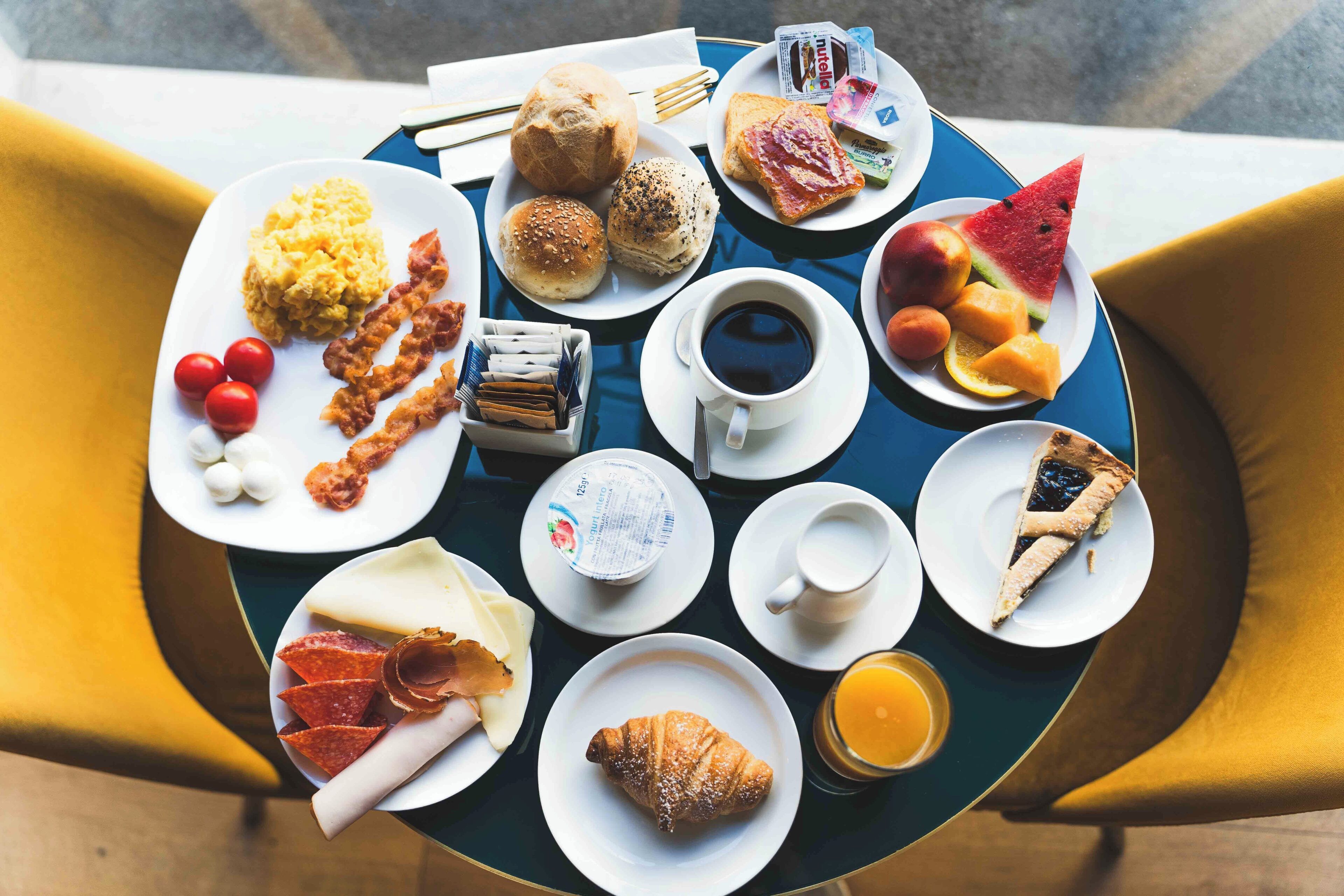 Una mesa de desayuno con diferentes alimentos y una taza de café.