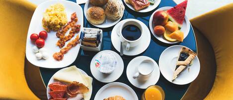 Una mesa de desayuno con diferentes alimentos y una taza de café.