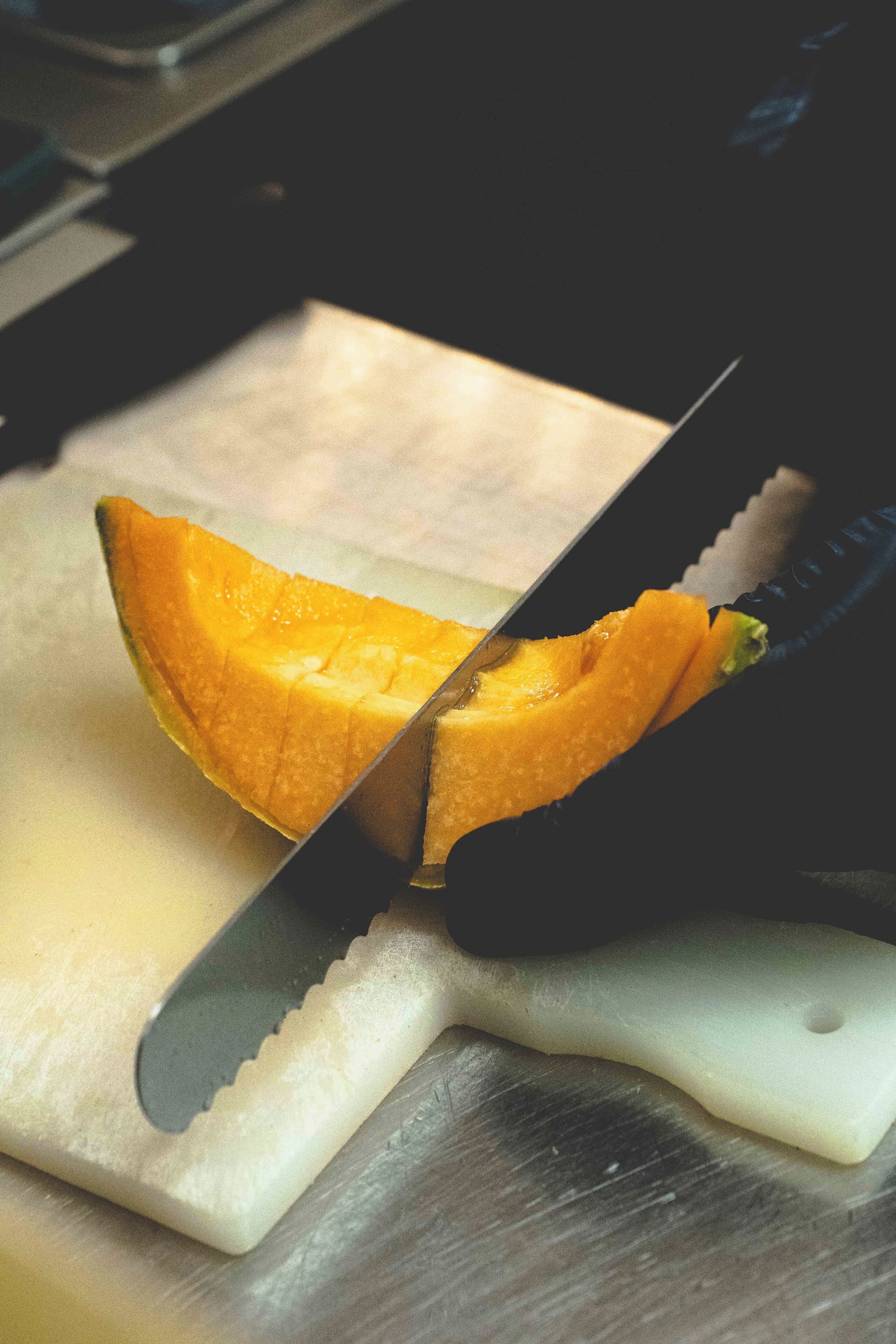 Una fruta cortada sobre una tabla con un cuchillo.