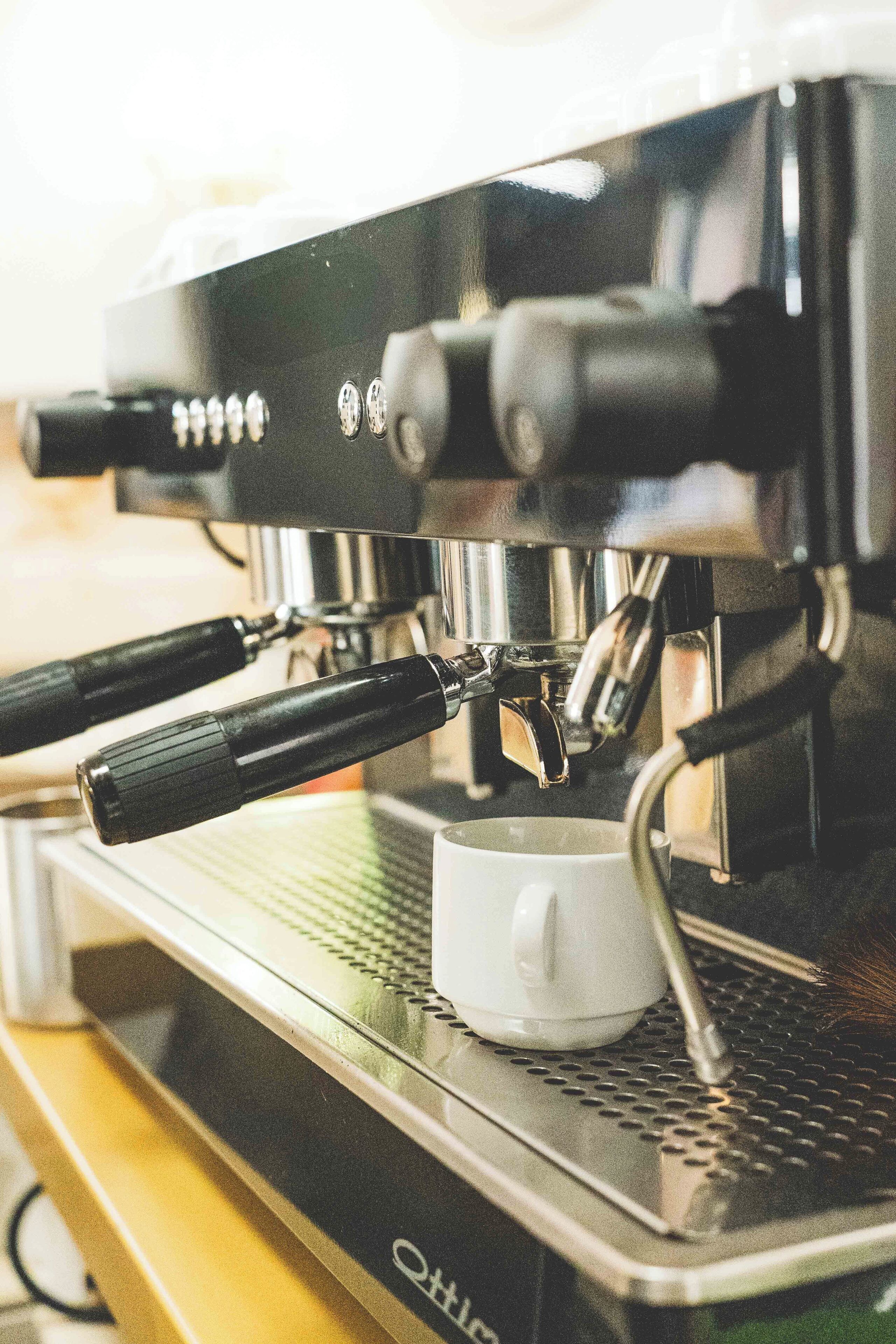 A coffee machine with a portafilter and a cup holder.