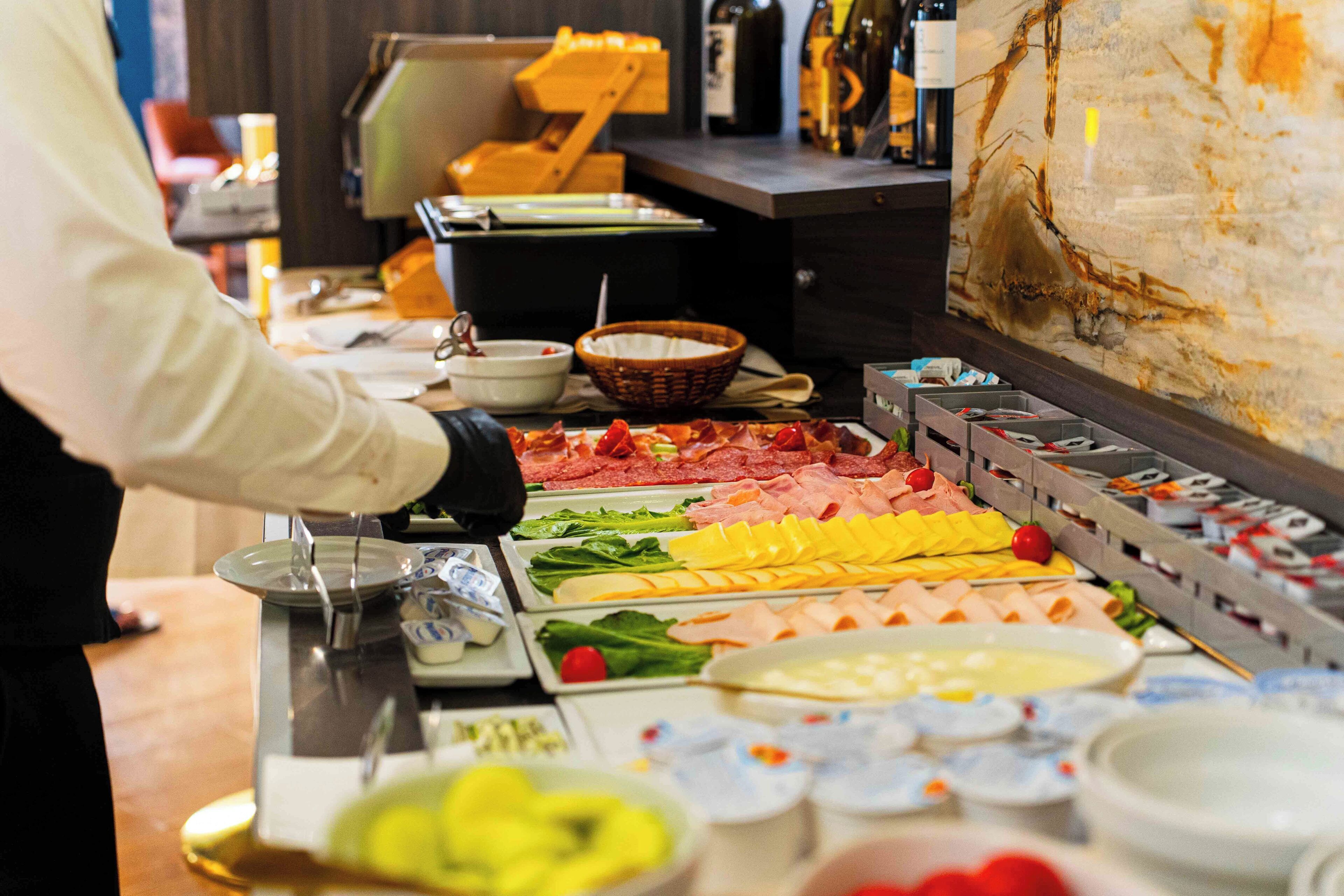 A buffet with various food items and a wine selection.
