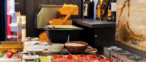 A buffet setup with various food items, a wine selection, and a wooden chair.