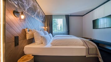 Ropa de cama hipoalergénica y caja de seguridad en la habitación