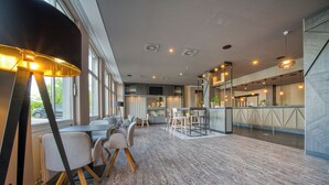Ein modernes Interieur mit Essbereich, Bar und großen Fenstern.