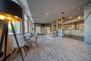 Un intérieur moderne comprenant un coin repas, un bar et de grandes fenêtres.
