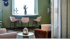 A room with two hanging pendant lights, a window with a view, and a table with a lantern.