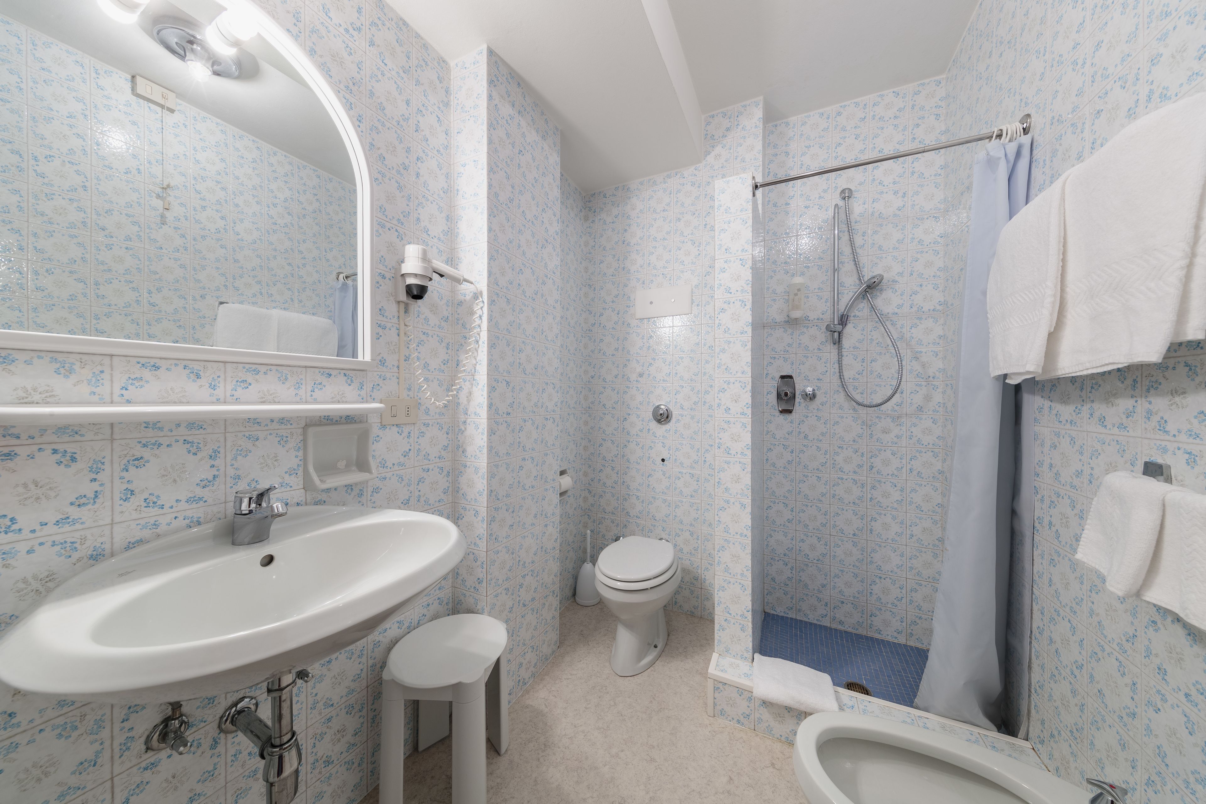 A bathroom with a sink, toilet, and shower.