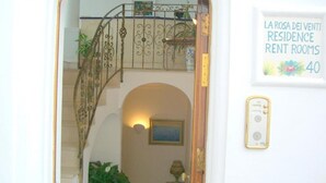 A staircase with ornate metal railings, a framed sign indicating 'Residence Rent Rooms 40', and a wall-mounted light fixture. - La Rosa dei Venti (Positano)
