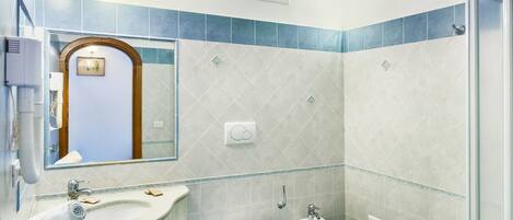 Et badeværelse med håndvask, toilet, bidet og bruseområde.
