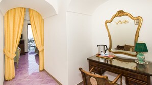 A room with a wooden dresser, a mirror with an ornate frame, a green lamp, and a tray with items on the dresser. - La Rosa dei Venti (Positano)