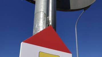 Señal con un triángulo rojo, una 'T' amarilla y el texto 'Via di Francesco Toscana'.