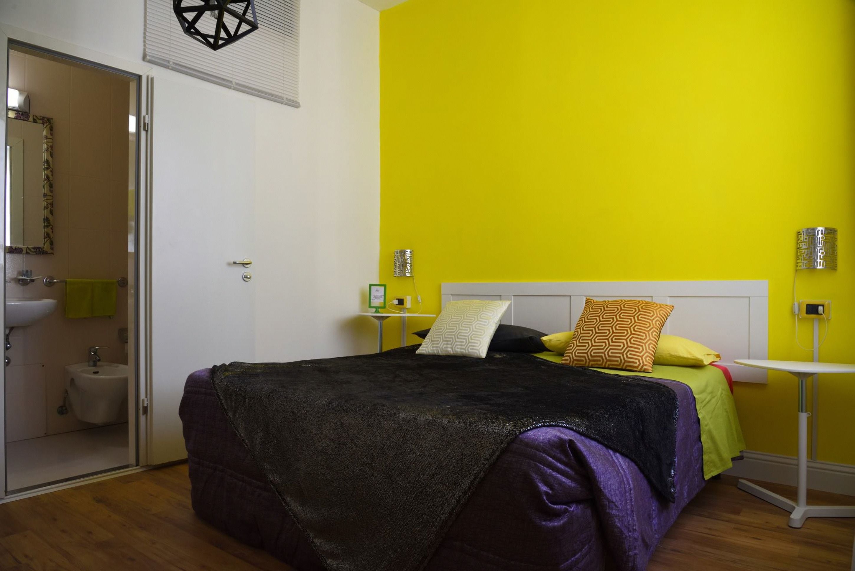 Un dormitorio con cama, mesita de noche y espejo.