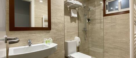 A modern bathroom with a sink, toilet, and glass-enclosed shower.