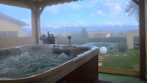 A hot tub with a view of a mountainous landscape through a window.