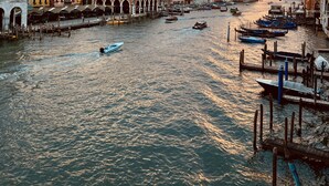 A canal with boats and historic buildings. - Locanda Leon Bianco on the Grand Canal (Venice)