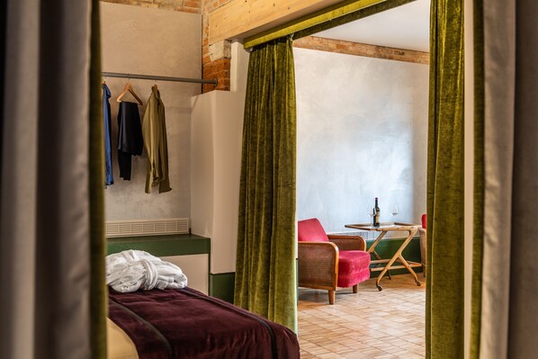 Una habitación con cama, una silla, una mesa y un ventanal.