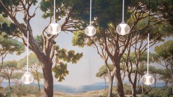 A room with a mural of trees and a view of the sea.