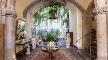 Enter a grand space with an arched ceiling, ornate columns, and a beautifully patterned rug.