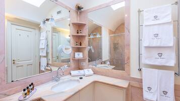 A bathroom with a large mirror, a sink, and a towel rack with towels.
