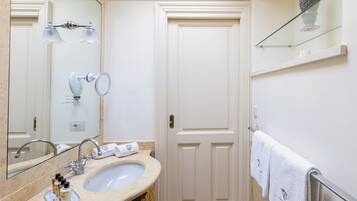 A bathroom with a sink, mirror, and towel rack.
