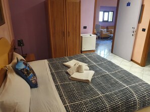 A hotel room with a bed, a wardrobe, a desk, and a chair. - Locanda dalla Compagnia (Riomaggiore)