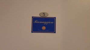 A blue sign with the number 5 and the text "Riomaggiore" and "Locanda della Campagna" on a beige wall. - Locanda dalla Compagnia (Riomaggiore)