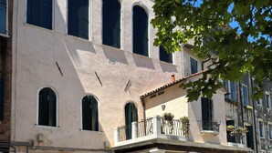 A building with a balcony, a sign indicating a restaurant, and a brick facade. - Locanda del Ghetto (Venice)