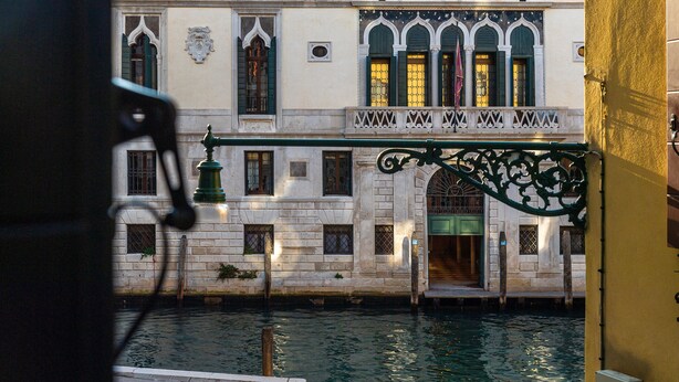 A canal view with a building featuring arched windows and a balcony. - Locanda Sant'Agostin (Venice)