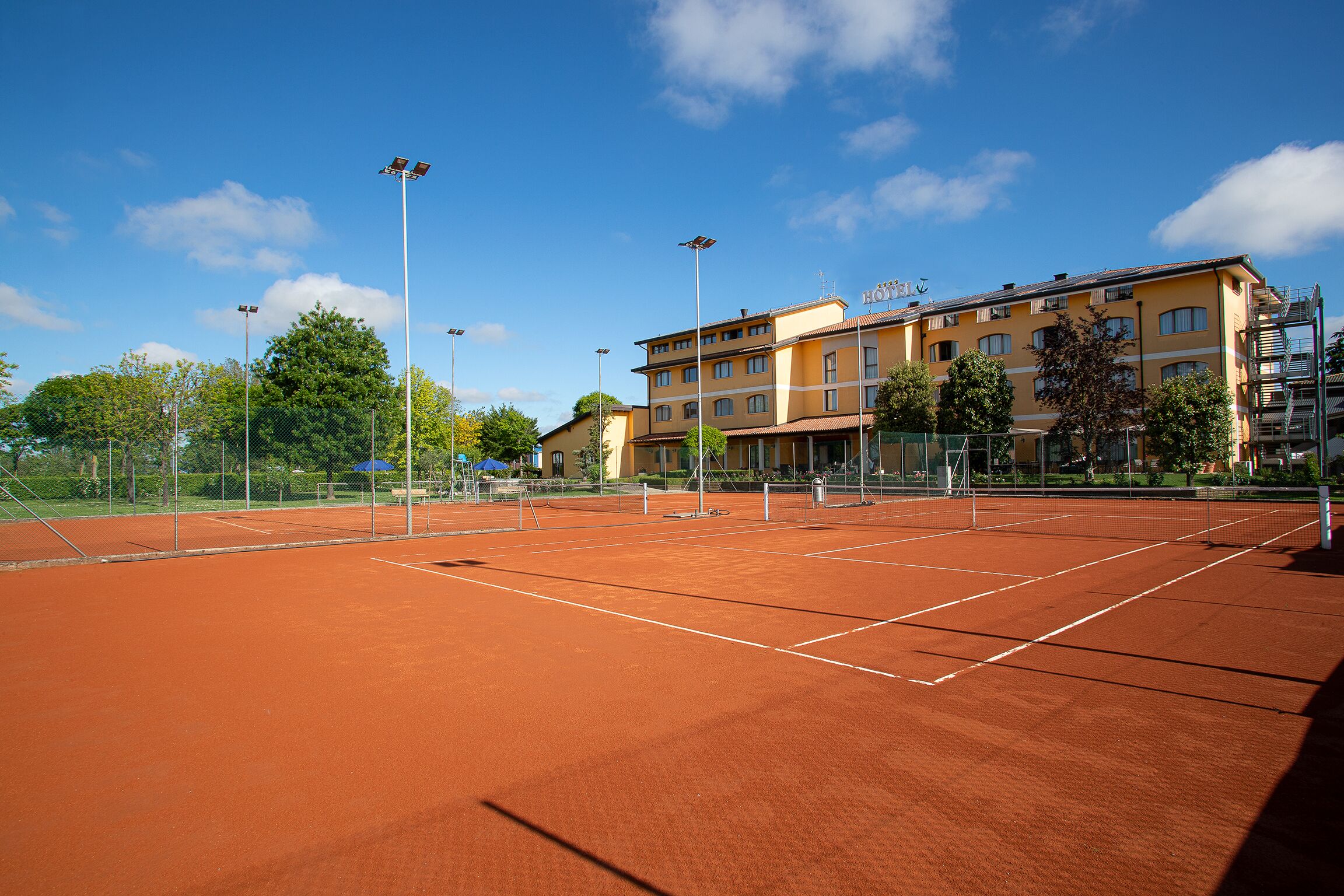 Una pista de tennis amb un edifici al fons.