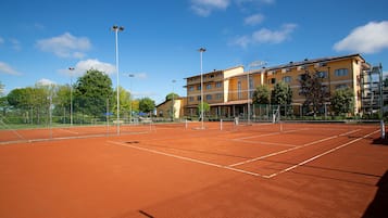 Una pista de tennis amb un edifici al fons.
