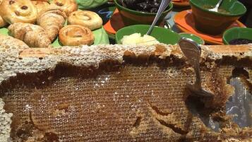 Un buffet con diversi dolci e un'imponente struttura a nido d'ape al centro.
