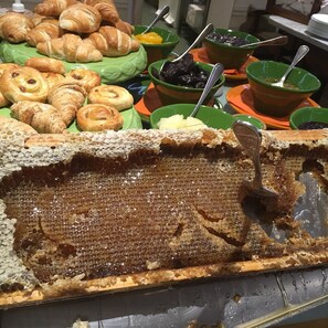 Un bufé con diversas opciones de pastelería y un llamativo panal en el centro.