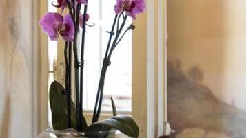 A vase with purple orchids on a table.