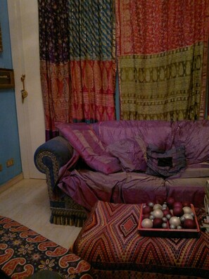 A room with a blue sofa, a patterned rug, and a tray of decorative items. - Abruzzese (Rome)
