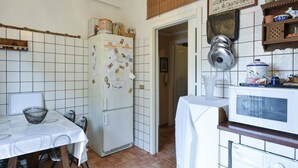 Une cuisine compacte équipée d’un réfrigérateur blanc, d’un four à micro-ondes et d’une table  à manger pour quatre personnes.